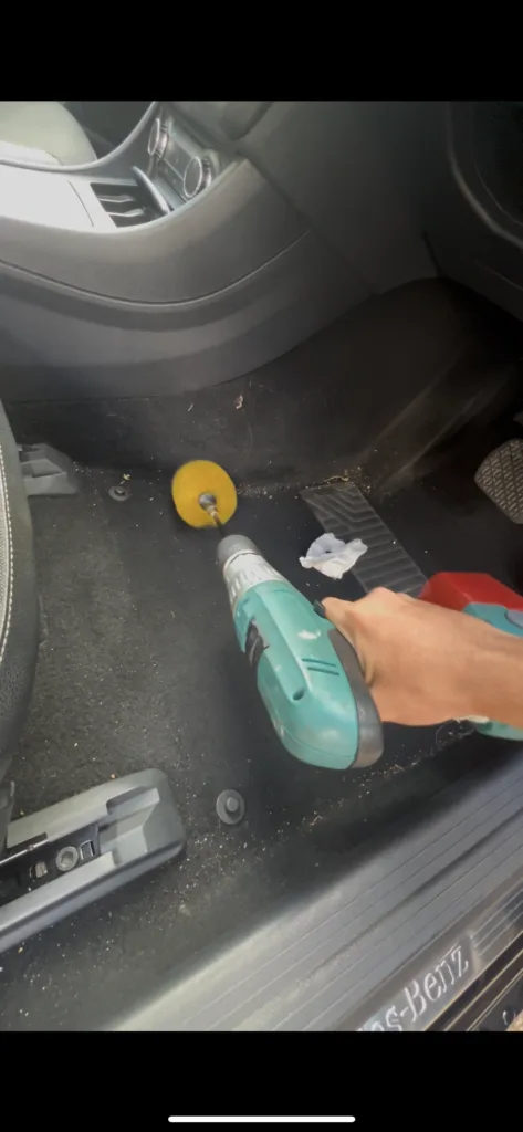 car footwell being drilled with a brush as part of an interior shampoo in croydon